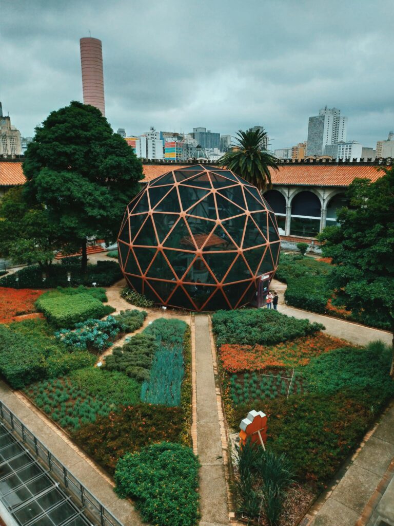 Explore a modern geodesic dome in a lush urban botanical garden setting.